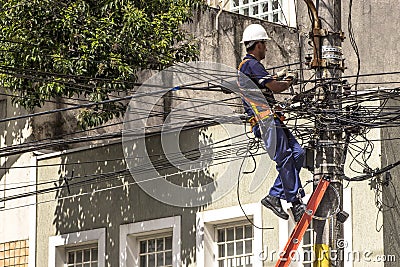 Company employee outsourced maintains an electric power transformer Editorial Stock Photo