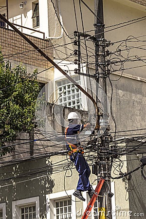 Company employee outsourced maintains an electric power transformer Editorial Stock Photo