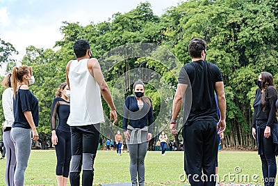 Sao Paulo, Sao Paulo, Brazil. July, 04 2021. 28-year-old Brazilian young man giving yoga class to a small group in the public Editorial Stock Photo