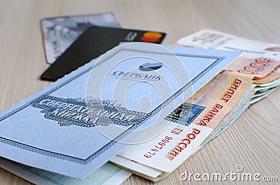 Saratov, RUSSIA - March 27: Plastic card of Sberbank, bank book, stack of russian money Editorial Stock Photo