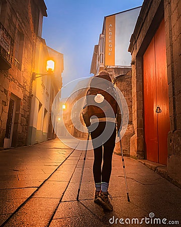 Lone Pilgrim Girl on Street in Old Town Sarria Spain early morning on Way of St James Camino de Santiago Editorial Stock Photo