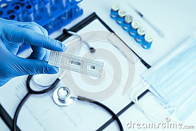 Sars test antigen coronavirus kit. Doctor holding rapid covid medical test. Laboratory hospital lab background. Patient Stock Photo