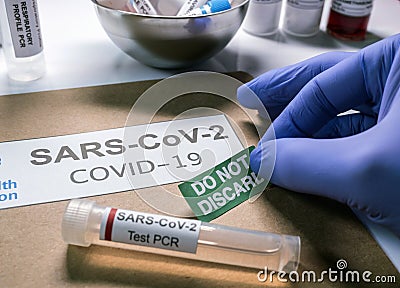 SarsCov2 coronavirus pcr vial together with a dossier folder indicating not to be discarded Stock Photo
