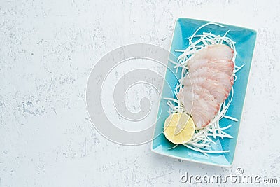 Sashimi from slices of raw white fish fillet on a blue plate on a white background. Copy space Stock Photo