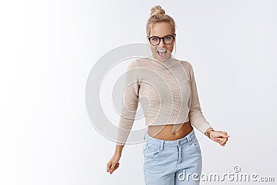 Sassy and cool attractive glamour blond woman in glasses and cropped top dancing shaking breast and hands singing Stock Photo