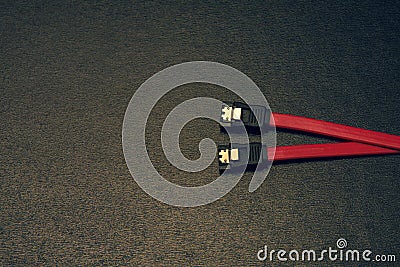 Sata computer cable on a black background. Sata as a new technology for connecting a hard drive to a computer. Stock Photo