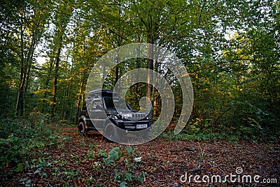 Sataniv, Ukraine - October 14, 2023: Suzuki Jimny off-road vehicle, roof rack luggage box, autumn evening. A car for tourism and Editorial Stock Photo