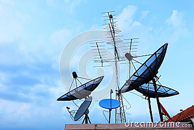 Satellite Dishes and TV antennas on the house roof Stock Photo