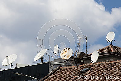 Satellite dishes and tv antennas on roof tops Stock Photo