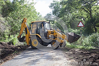 Sathyamangalam, Tamil Nadu, India - June 24, 2015: An excavator doing roadwork in the middle of the Sathyamangalam forest. Editorial Stock Photo