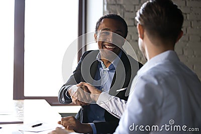 Satisfied black client shaking hands thanking manager for good d Stock Photo