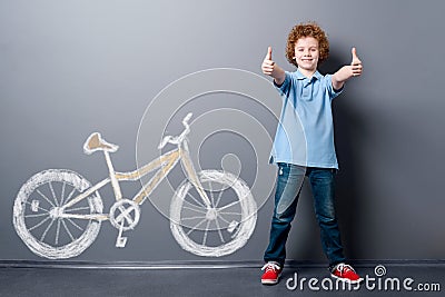 Satisfied boy and yellow bicycle Stock Photo