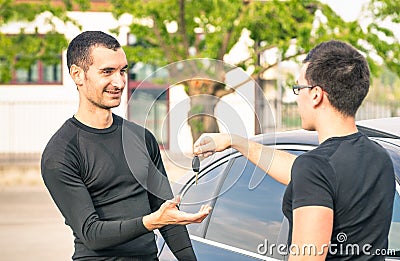 Satisfied buyer man receiving car keys after second hand sale Stock Photo