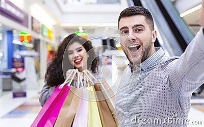 Satisfied couple making selfie after shopping in mall Stock Photo