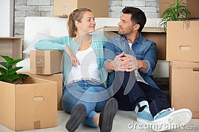 satisfied couple sat amongst cardboard boxes Stock Photo