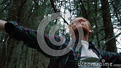 Satisfied guy taking rest during hike in woods. Male tourist enjoying nature Stock Photo