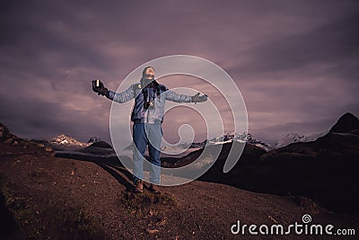 A satisfied happy trekker is enjoying the sun rise with a cup of tea i dzongri hilltop Editorial Stock Photo