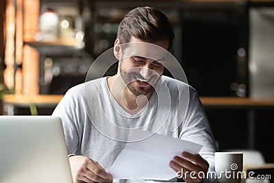 Satisfied millennial businessman reading paper letter with good news Stock Photo