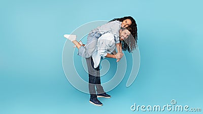 Satisfied millennial caucasian man holding arab female on back, have fun, enjoy tender moment Stock Photo