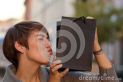 Satisfied shopper kissing her boutique bag Stock Photo