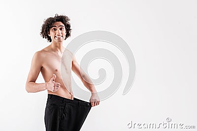 Satisfied slender guy wearing oversized pants Stock Photo