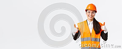 Satisfied smiling female asian chief construction engineer giving permission to enter building or entertprise after Stock Photo