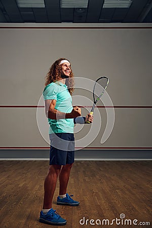 Satisfied squash player clenching fist rejoicing win in game Stock Photo