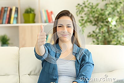 Satisfied woman looking at camera with thumbs up Stock Photo