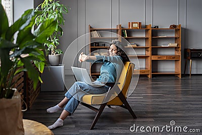 Satisfied with work done woman stretch hands relax sit in cozy armchair with laptop in home office Stock Photo