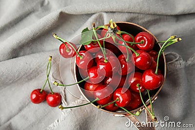 Saucepan with sweet red cherries on fabri Stock Photo