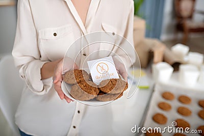 Saucer of gluten-free freshly baked cookies in female hands. Stock Photo