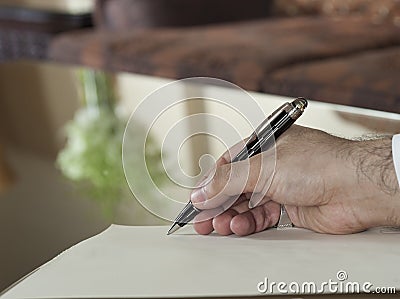 Saudi Arabian Man Hand Writing on A Notebook Stock Photo