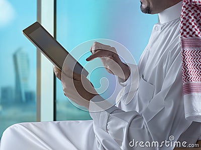 Saudi Arabian Man Using Tablet Beside Window Stock Photo