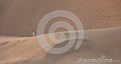 A Saudi couple take a selfie in the huge sand dunes in Badr, Medina, Saudi Arabia Stock Photo