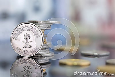 Saudi Riyal pounds with a golden one on a reflective surface Stock Photo