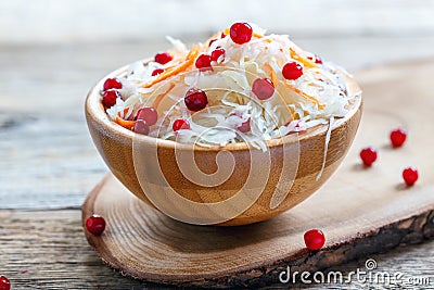 Sauerkraut with cowberry in a wooden bowl. Stock Photo