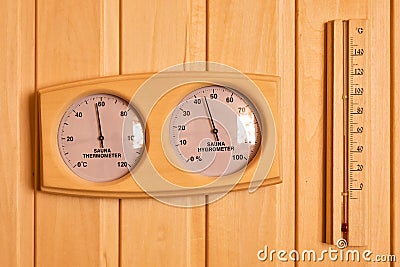 Sauna thermometer and hygrometer on wooden wall. Temperature in celsius Stock Photo