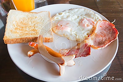 Sausage, bacon, double eggs, and white bread toast for breakfast Stock Photo