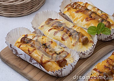 Sausage bread with yellow cheddar cheese, mayo and ketchup. Stock Photo