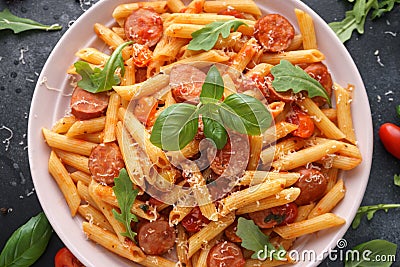 Sausage penne Pasta with tomato sauce and fresh herbs Stock Photo