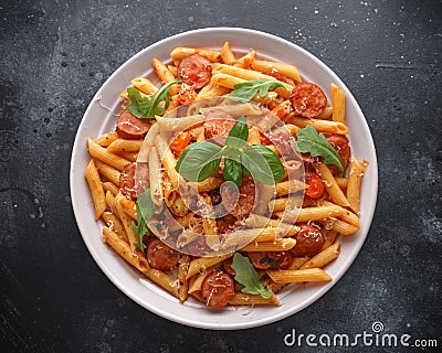 Sausage penne Pasta with tomato sauce and fresh herbs Stock Photo