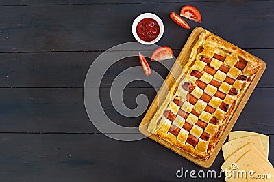 Sausage pie in puff pastry on dark background Stock Photo