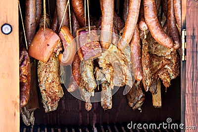 Sausages and bacon inside wooden smokers Stock Photo