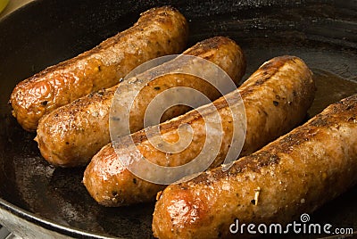 Sausages in a black frying pan Stock Photo