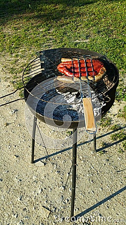Sausages cooking on barbecue Stock Photo