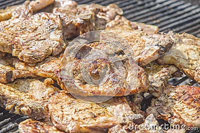 Sausages and pork steaks on the large barbeque Stock Photo