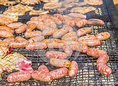 Sausages and pork steaks on the large barbeque Stock Photo