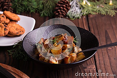 Sauteed sweet potato salad on black bowl on brown wooden background. Side dish for christmas, thanksgiving, and new year's eve din Stock Photo