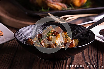 Sauteed sweet potato salad on black bowl on brown wooden background. Side dish for christmas, thanksgiving, and new year's eve din Stock Photo