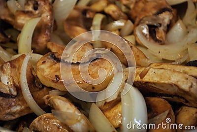 Sauteing mushrooms and onions in a frying pan with oil, seasoning, and steam Stock Photo